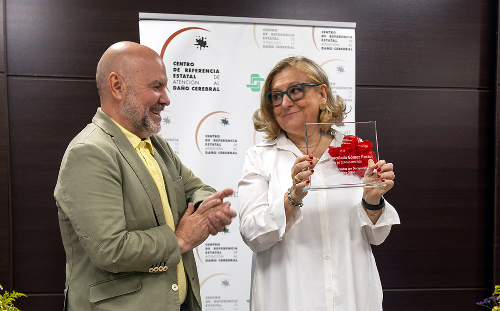 Luis Cayo Pérez, presidente del CERMI Estatal, entregando la placa de reconocimiento a Inmaculada Gómez Pastor, directora gerente del Ceadac.